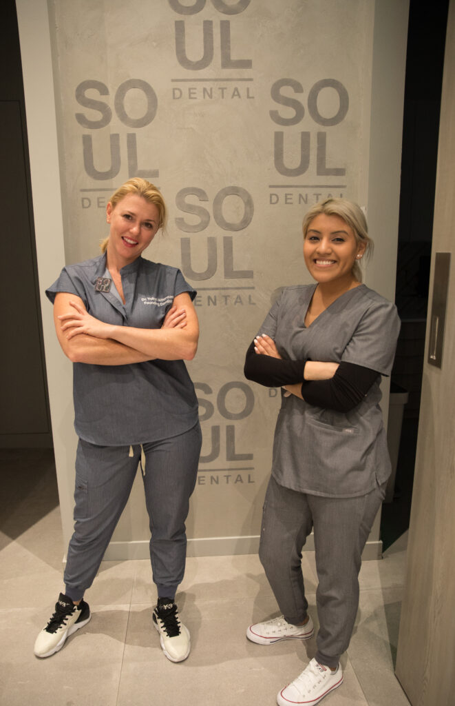 Dr. Yuliya and a Soul Dental staff member pose, arms folded, smiling, looking sassy and fun.